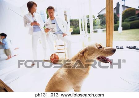 Stock Image - A family sitting out with their pet. Fotosearch