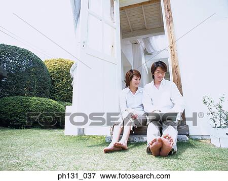 Asian couple sitting at the door View Large Photo Image Stock Photo - Asian couple sitting at the door. Fotosearch