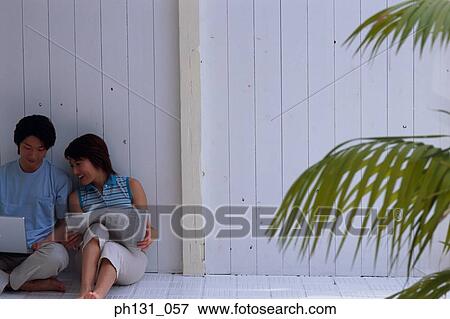 Asian couple working together on a laptop View Large Photo Image Stock Photo - Asian couple working together on a laptop. Fotosearch