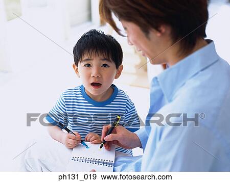 Asian father and son coloring in a notebook View Large Photo Image Stock Photo - Asian father and son coloring in a notebook. Fotosearch