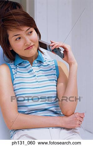 Asian Woman holding a cell phone View Large Photo Image Stock Image - Asian Woman holding a cell phone. Fotosearch