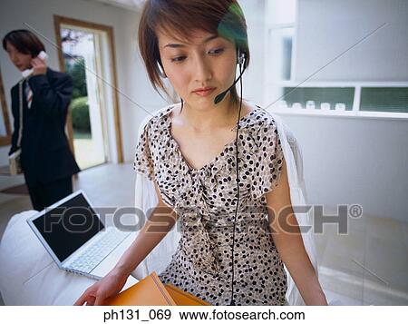 Asian woman wearing a headset View Large Photo Image Stock Photo - Asian woman wearing a headset. Fotosearch