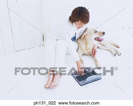 Stock Image - Asian Woman working on a laptop. Fotosearch