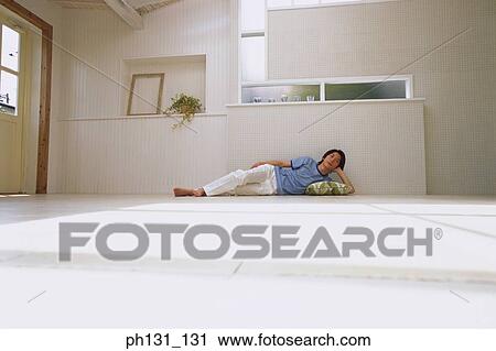 Stock Image - Asian Man lying on the floor. Fotosearch
