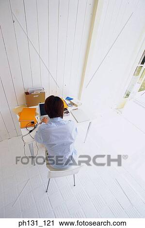 Stock Image - Asian man working on a desk. Fotosearch