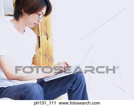 Asian man working on a laptop View Large Photo Image Stock Image - Asian man working on a laptop. Fotosearch