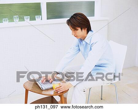 Asian man working on a laptop View Large Photo Image Stock Photo - Asian man working on a laptop. Fotosearch