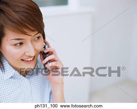 Stock Image - Asian woman talking on the cell phone. Fotosearch