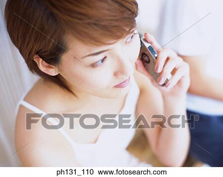 Stock Image - Asian woman talking on the cell phone. Fotosearch