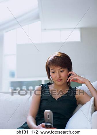 Stock Image - Asian woman using a cell phone. Fotosearch