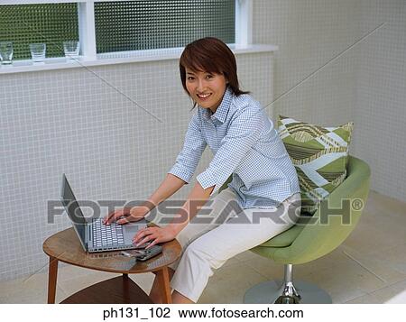 Asian woman using a laptop View Large Photo Image Stock Image - Asian woman using a laptop. Fotosearch