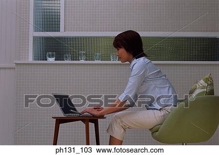 Stock Image - Asian woman using a laptop. Fotosearch