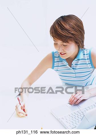Asian woman working on a desk View Large Photo Image Stock Photograph - Asian woman working on a desk. Fotosearch