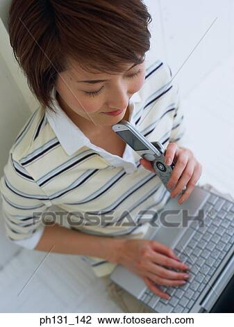 Asian Woman working on a laptop View Large Photo Image Stock Image - Asian Woman working on a laptop. Fotosearch