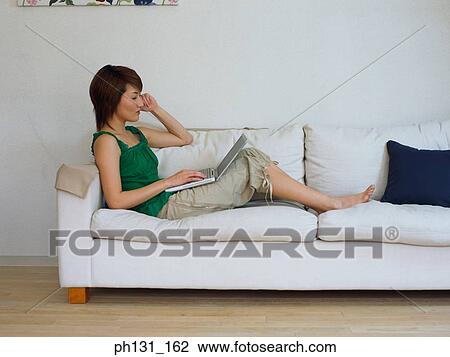 Asian Woman working on a laptop View Large Photo Image Stock Image - Asian Woman working on a laptop. Fotosearch