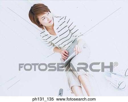 Stock Photography - Asian Woman working on a laptop. Fotosearch