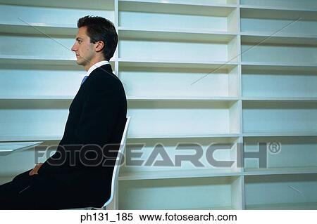 Stock Photography - Caucasian man sitting in an empty office. Fotosearch