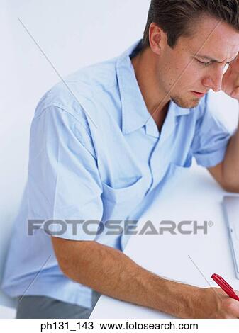 Caucasian man working on a desk View Large Photo Image Stock Image - Caucasian man working on a desk. Fotosearch