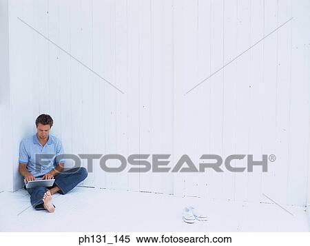 Caucasian man working on a laptop View Large Photo Image Stock Photography - Caucasian man working on a laptop. Fotosearch