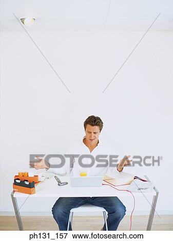 Caucasian sitting on a desk View Large Photo Image Stock Photo - Caucasian sitting on a desk. Fotosearch