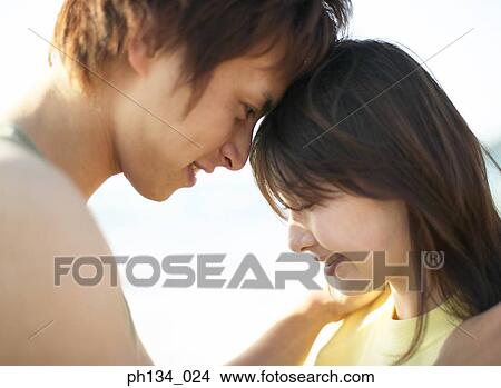 Picture - Young couple with their heads together. Fotosearch