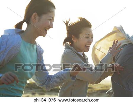 Stock Photograph - Young female friends running. Fotosearch