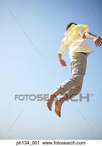 Stock Image - Young man jumping high. Fotosearch