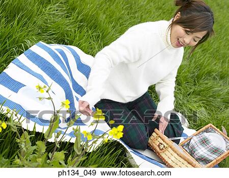 Young woman sitting with a picnic basket View Large Photo Image Stock Photo - Young woman sitting with a picnic basket. Fotosearch