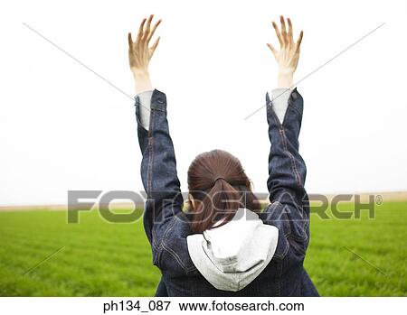Young woman with raised hands View Large Photo Image Stock Photo - Young woman with raised hands. Fotosearch