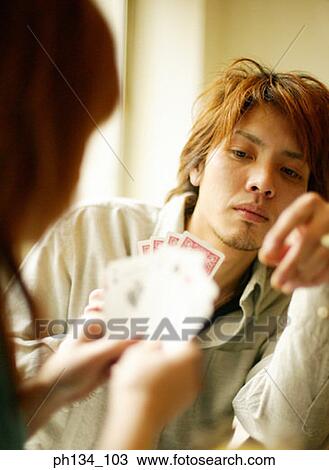 Stock Image - Young couple playing cards. Fotosearch