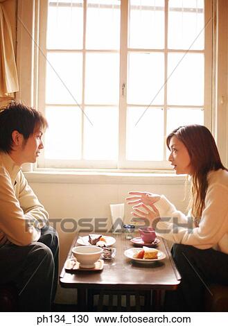 Stock Image - Young couple sitting together. Fotosearch