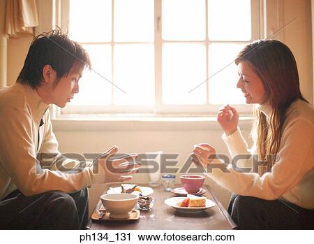 Young couple sitting together View Large Photo Image Stock Image - Young couple sitting together. Fotosearch