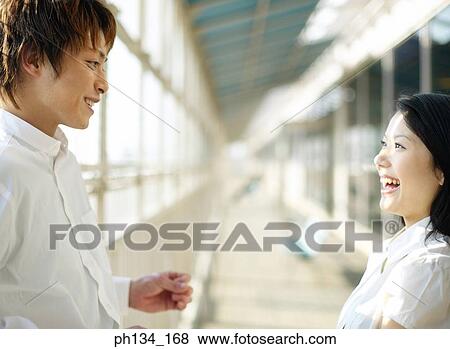Stock Photo - Young couple standing and talking. Fotosearch