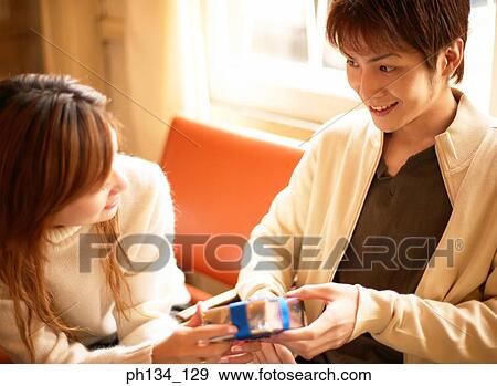 Young couple with gift View Large Photo Image Stock Photo - Young couple with gift. Fotosearch