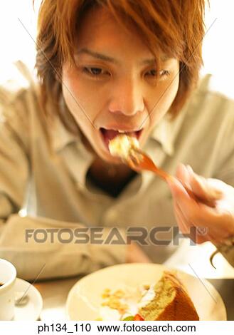 Young man eating View Large Photo Image Stock Image - Young man eating. Fotosearch