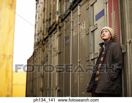 Young man leaning against a cargo container View Large Photo Image Stock Image - Young man leaning against a cargo container. Fotosearch