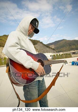 Young man playing guitar View Large Photo Image Stock Image - Young man playing guitar. Fotosearch