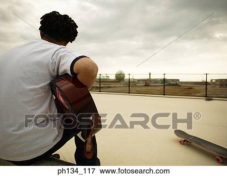 Young man playing guitar View Large Photo Image Stock Photo - Young man playing guitar. Fotosearch