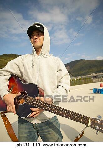 Stock Photo - Young man playing guitar. Fotosearch