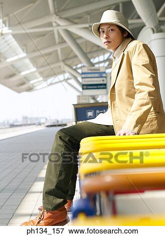 Stock Photo - Young man sitting and waiting. Fotosearch
