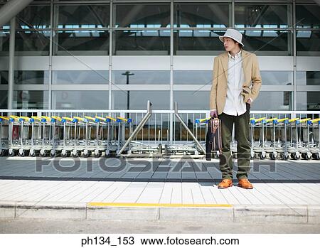 Young man waiting outside airport View Large Photo Image Stock Image - Young man waiting outside airport. Fotosearch
