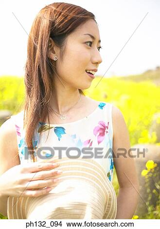 Picture - Young woman holding cap. Fotosearch