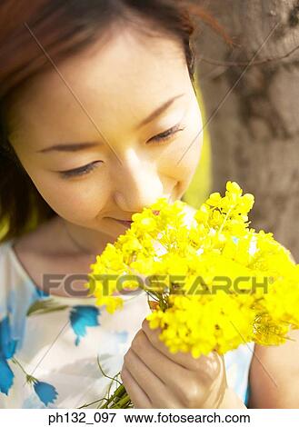 Stock Photo - Young woman holding flowers. Fotosearch