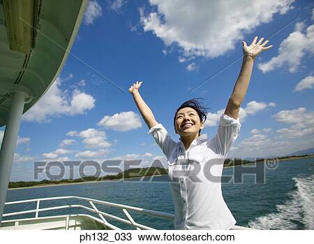 Young woman on a boat with arms outstretched View Large Photo Image Stock Image - Young woman on a boat with arms outstretched. Fotosearch