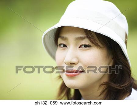 Young woman wearing a cap smiling View Large Photo Image Stock Photo - Young woman wearing a cap smiling. Fotosearch