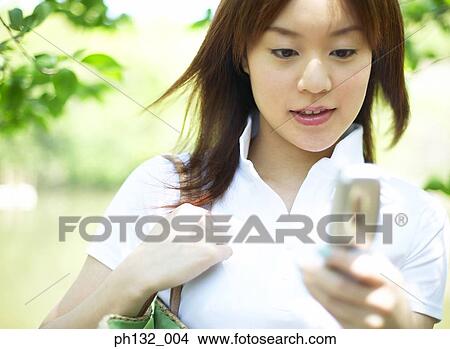 Picture - Young woman with mobile phone. Fotosearch