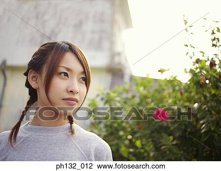Young women standing in a garden View Large Photo Image Stock Image - Young women standing in a garden. Fotosearch