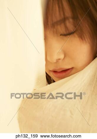 Stock Photo - Young woman asleep under covers. Fotosearch