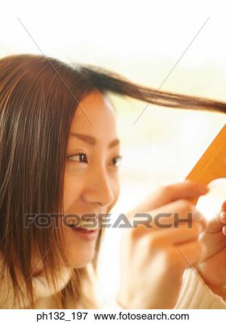 Young woman combing hair View Large Photo Image Stock Photo - Young woman combing hair. Fotosearch