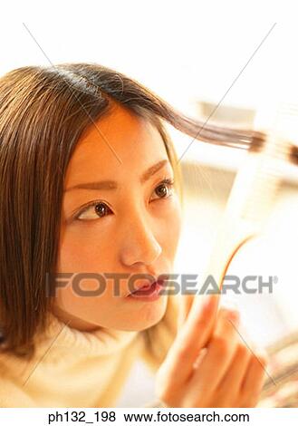 Young woman combing hair View Large Photo Image Stock Photo - Young woman combing hair. Fotosearch